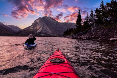 Adventurous Man Kayaking in Glacier Lake clipart