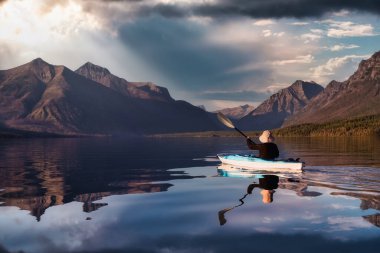 Adventurous Man Kayaking in Lake McDonald clipart