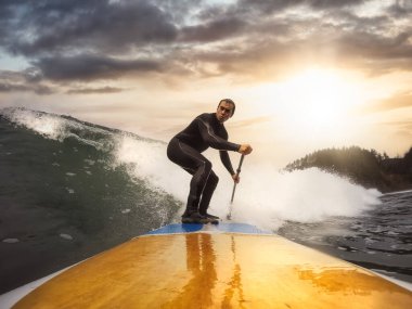 Maceracı Adam Pasifik Okyanusunda dalgalarda sörf yapıyor.