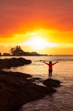 Maceraperest Kız Rocky Okyanus Kıyısı 'nın Güzel Manzarasının tadını çıkarıyor.