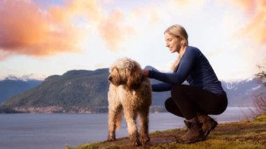 Bir köpekle dağın tepesinde gezinen maceracı kız. Sinemagraf Devamlı Döngü Canlandırması.