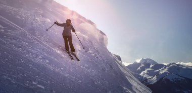 Güzel, karlı bir dağda kayak yapan maceracı kız.