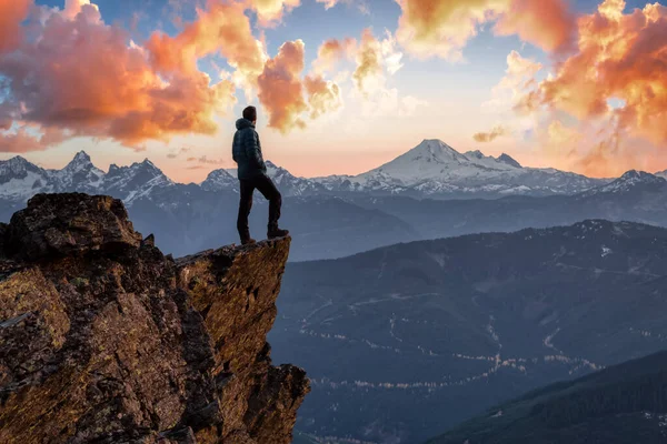 冒険好きな男が山の上に立っている — ストック写真