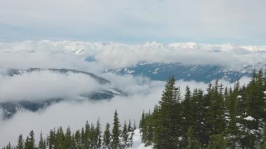 Kışın bulutlu bir sabahta dağların tepesinde karlı bir manzara.
