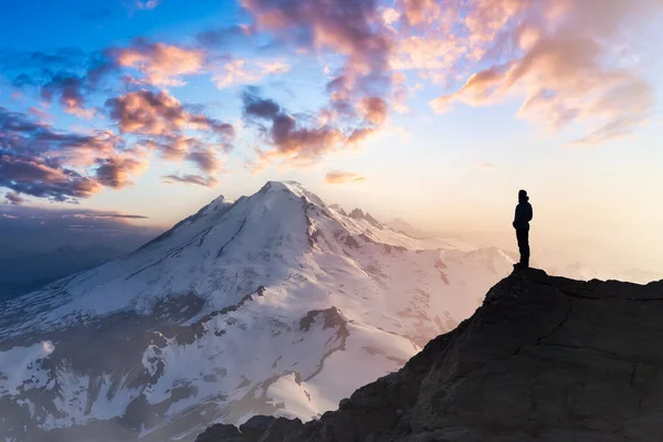 Avventuroso uomo escursionista sulla cima di una ripida scogliera rocciosa. — Foto Stock