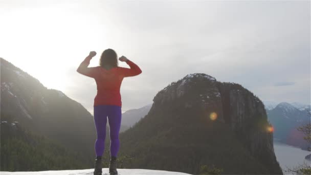 Chica aventurera Senderismo en las montañas durante un soleado atardecer de invierno. — Vídeos de Stock