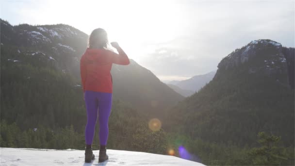 Adventurous Girl Hiking in the mountains during a sunny Winter Sunset. — Stock Video