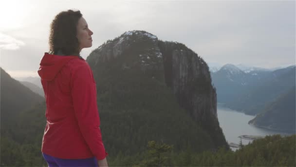 Chica aventurera Senderismo en las montañas durante un soleado atardecer de invierno. — Vídeos de Stock