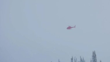 Helicopter flying in poor visibility and snow winter conditions