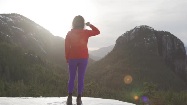Adventurous Girl Hiking in the mountains during a sunny Winter Sunset. — Stock Video