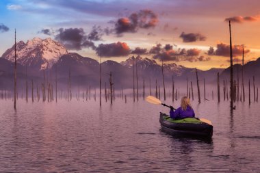 Maceraperest Kız, güzel bir gölde delicesine kayak yapıyor.