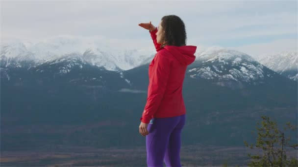 Fille aventureuse Randonnée dans les montagnes pendant un coucher de soleil d'hiver ensoleillé. — Video