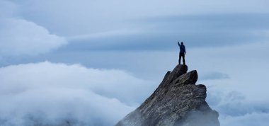 Bileşik. Dik bir kayalığın tepesinde Maceracı Yürüyüşçü.