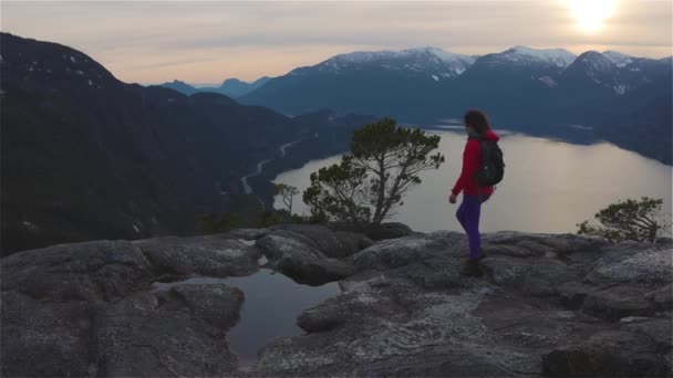 Chica aventurera Senderismo en la cima de un pico — Vídeo de stock