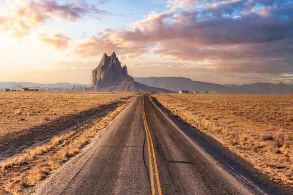 Pohled na silnici v suché poušti s horským vrcholem Shiprock v pozadí. — Stock fotografie