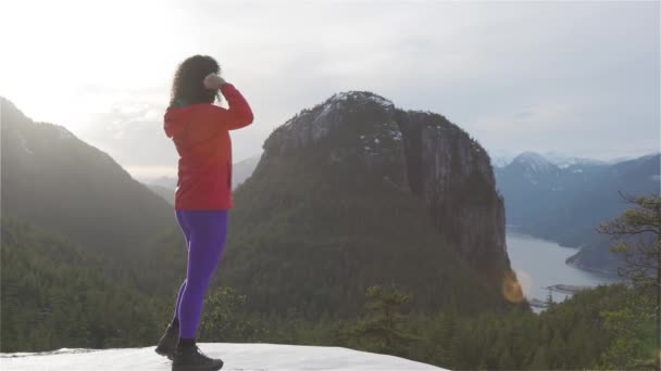 Adventurous Girl Hiking in the mountains during a sunny Winter Sunset. — Stock Video