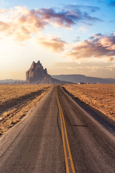 Pohled na silnici v suché poušti s horským vrcholem Shiprock v pozadí. — Stock fotografie