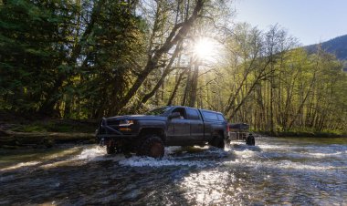 Nehirden geçen yükseltilmiş süspansiyon tekerleri olan özel bir 4x4 Truck.