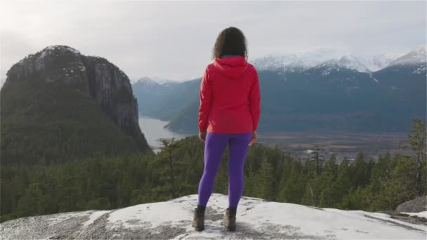 Chica aventurera Senderismo en las montañas durante un soleado atardecer de invierno. — Vídeo de stock