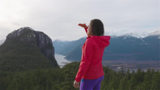 Menina aventurosa Caminhadas nas montanhas durante um pôr-do-sol ensolarado de inverno. — Vídeo de Stock