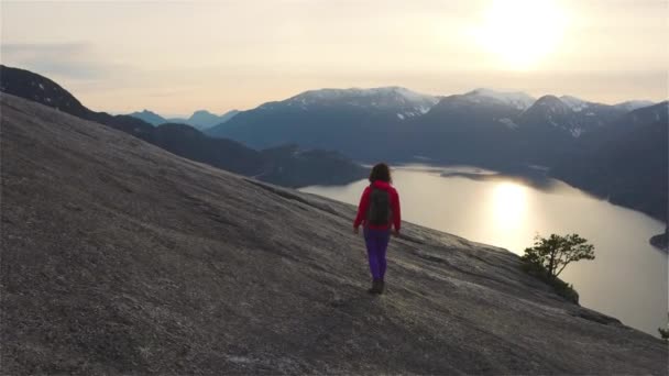 Chica aventurera Senderismo en la cima de un pico — Vídeo de stock