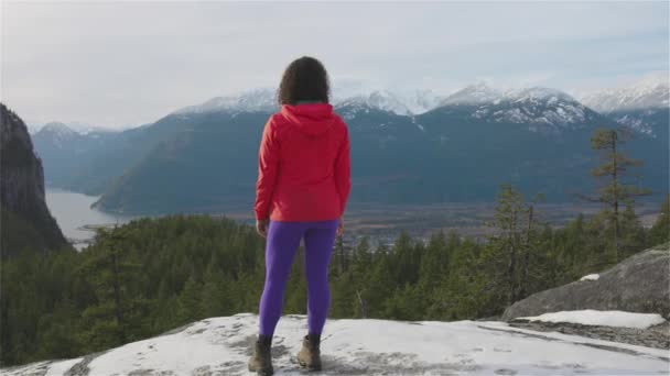 Chica aventurera Senderismo en las montañas durante un soleado atardecer de invierno. — Vídeo de stock