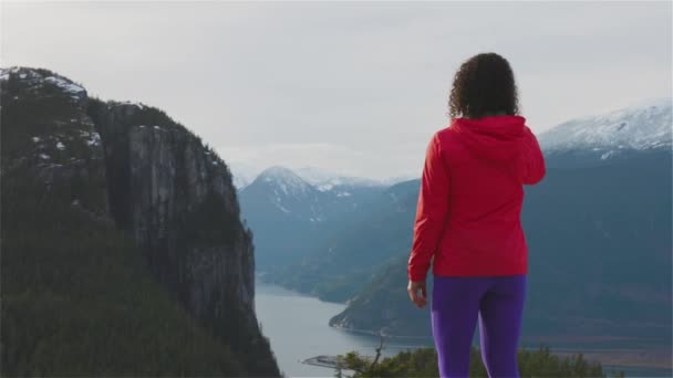 Fille aventureuse Randonnée dans les montagnes pendant un coucher de soleil d'hiver ensoleillé. — Video