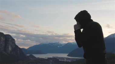 Siyah kapüşonlu beyaz adam gölge boksu yapıyor.