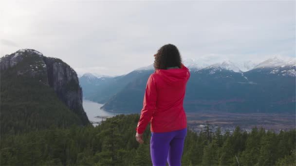 Fille aventureuse Randonnée dans les montagnes pendant un coucher de soleil d'hiver ensoleillé. — Video