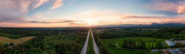 Fraser Vadisi 'ndeki Trans-Canada Otoyolu' nun renkli bahar günbatımında hava panoramik görüntüsü. Büyük Vancouver, İngiliz Kolombiyası, Kanada.