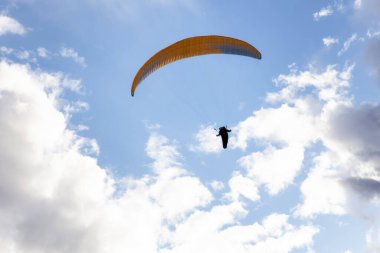 Maceracı Adam dağların etrafında bir paraglider üzerinde uçuyor..