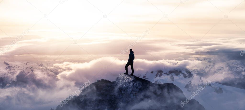 Man Hiking on top of a rocky mountain peak