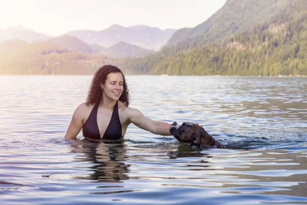 Caucásico Mujer nadando en un lago con perro —  Fotos de Stock