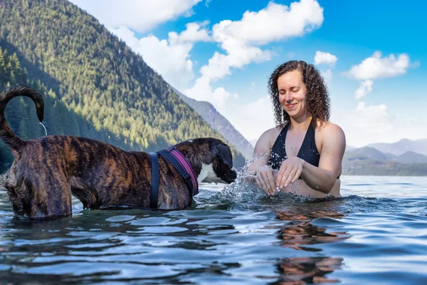Caucásico Mujer nadando en un lago con perro — Foto de Stock