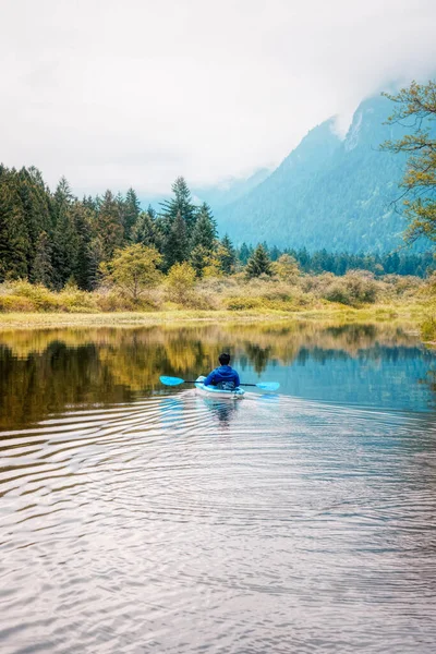 Aventure Homme adulte Kayak dans Blue Kayak entouré par la montagne canadienne — Photo