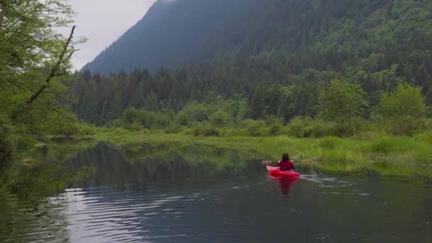 Abenteuer Kaukasische erwachsene Frau Kajak fahren im roten Kajak — Stockvideo