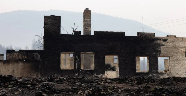 一座小城镇房屋的燃烧碎片，天空中弥漫着浓烟. — 图库照片