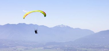 Maceracı Kadın Kanada Dağları 'nın çevresinde bir paraglider üzerinde uçuyor.