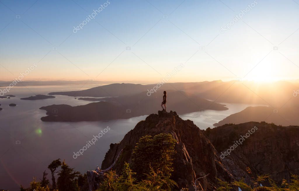 Adventurous Caucasian Woman Hiking on top of a Rocky Mountain Cliff.