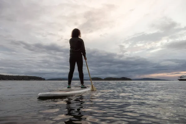 Avontuurlijk witte volwassen vrouw peddelen in de Stille Oceaan — Stockfoto