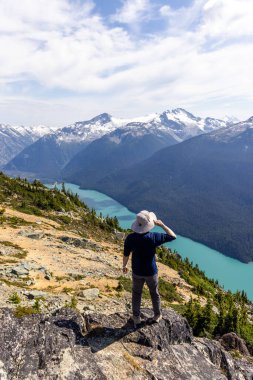 Yürüyüşçü Whistler, BC, Kanada 'da turkuaz göle bakan manzaralı dağ manzarasını seviyor..
