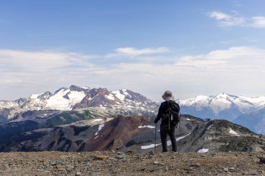 Whistler, BC, Kanada 'da yürüyüş yapan bir adam, nefes kesen karlı dağ manzaralarına hayran..