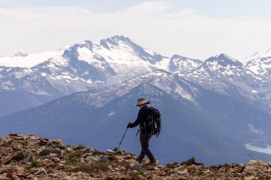 Kanada Whistler 'da engebeli dağ arazisinde yürüyüş yapan yürüyüşçü nefes kesici manzarası ile.