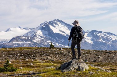 Yürüyüşçü Whistler, BC, Kanada 'da karla kaplı muhteşem dağ manzarasının tadını çıkarıyor..