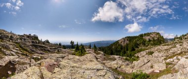 Vancouver, BC, Kanada 'da güneşli mavi bir gökyüzü altında Rocky dağları ve ormanlar.