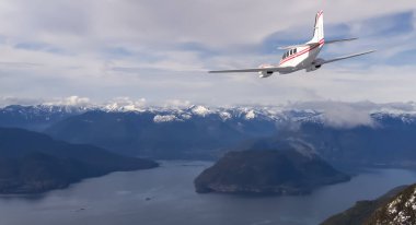 BC, Kanada 'da güzel dağların ve göllerin üzerinden süzülen 3D uçak