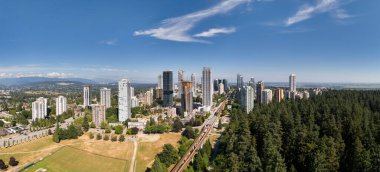 İngiliz Kolombiya 'sında yeşil doğa ve ormanlarla çevrili kentsel ufuk çizgisi.