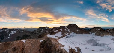 Karlı dağ tepelerinin manzarası ve BC, Kanada 'da canlı gün batımı