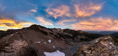 Manzaralı Britanya Kolombiya, Kanada 'da canlı gündoğumu bulutlarıyla dramatik dağ zirveleri.