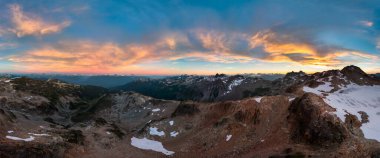 BC, Kanada 'da gün batımında kar kaplı dağların çarpıcı manzarası.